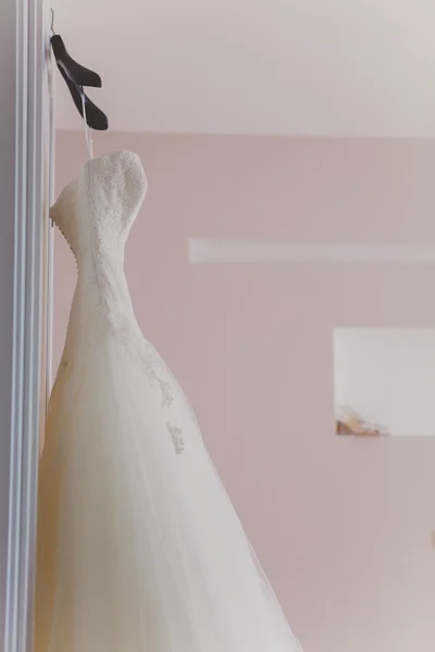 Vestido de casamento branco pendurado em um ombro — Fotografia de Stock