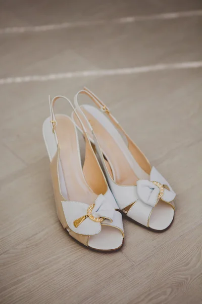 Bílé svatební boty s lukem na pozadí — Stock fotografie