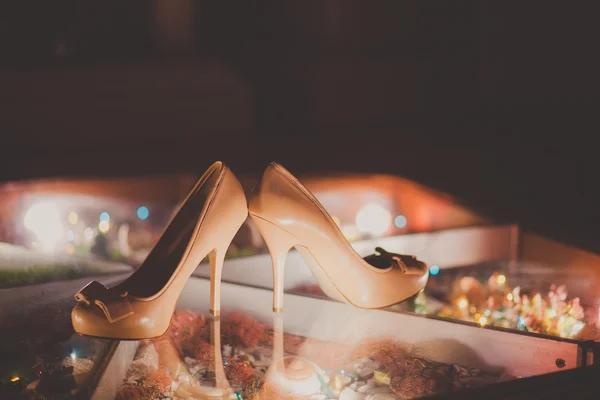 Sapatos de casamento com um arco no chão luminoso — Fotografia de Stock