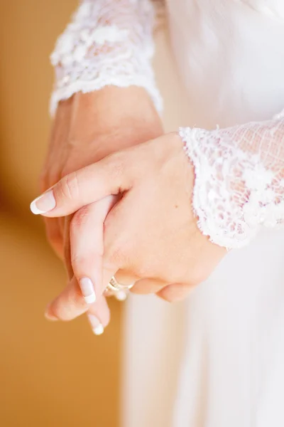 Spitze weißes Hochzeitskleid mit langen Ärmeln. Frauenhände. — Stockfoto