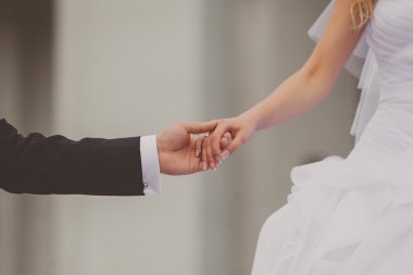 Gelin ve damat dışarıda el ele tutuşuyorlar.