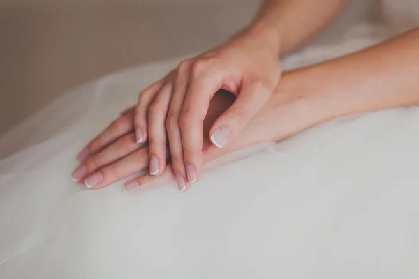 Bräute Hände auf einem Hochzeitskleid — Stockfoto