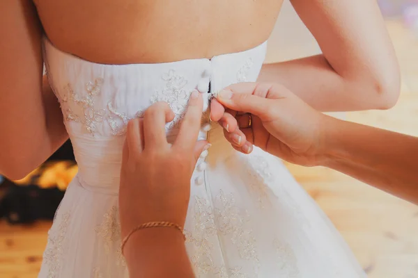 Preparação nupcial, noiva colocando em um vestido de noiva elegante — Fotografia de Stock