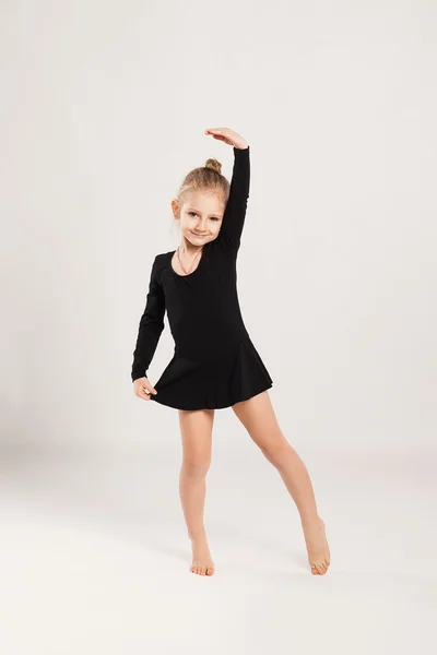 Маленькая веселая гимнастка показывает упражнение — стоковое фото