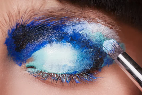 Makeup. Make-up. Painting blue eyeshadows. Eye shadow brush — Stok fotoğraf