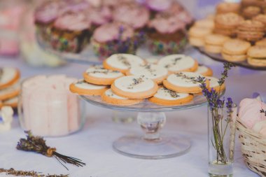 Tatlı tablo bir düğün için. Lavanda çiçeklerle süslenmiş bisküvi