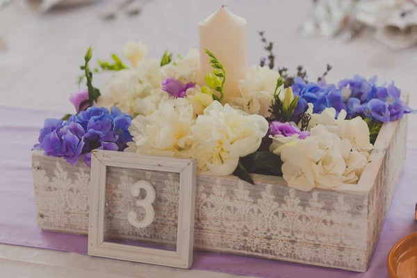 Wild flowers in a wooden tub on festive table — Stock Photo, Image