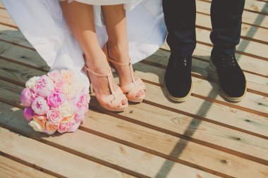 Gelin ve damatlar ayakkabı peonies buket ile kahverengi ahşap zemin üzerinde
