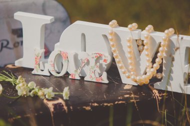 Vintage kahverengi deri arka plan üzerinde inci boncuklar ile aşk sözcükleri