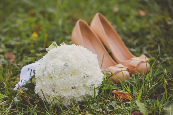 Γαμήλια παπούτσια και νυφικό μπουκέτο λευκά λουλούδια εξωτερική — Φωτογραφία Αρχείου