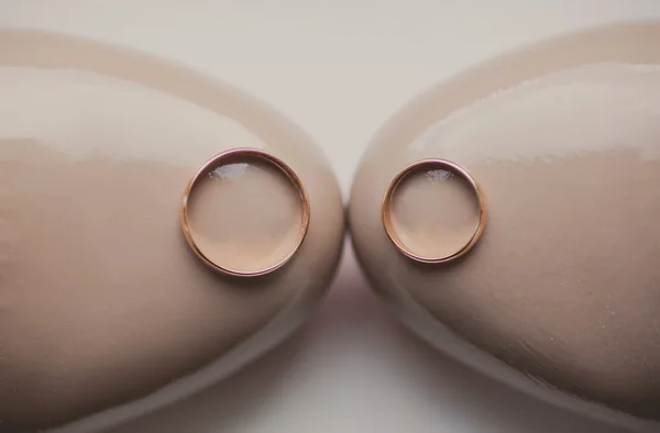 Два золотых кольца на бежевых свадебных туфлях — стоковое фото