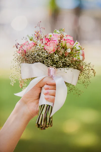 Brud holding bröllop bukett med rosett — Stockfoto