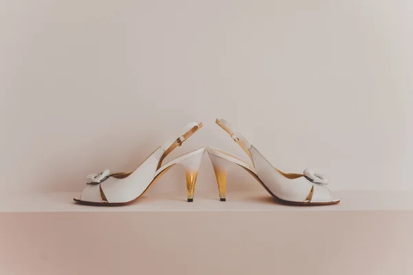 Scarpe da sposa bianche con fiocco su fondo legno — Foto Stock