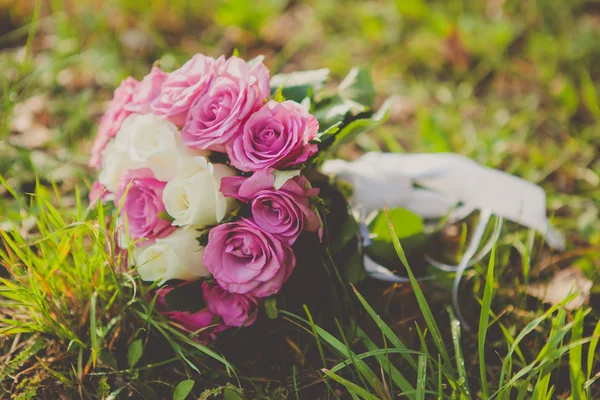 Ramo de boda de rosas rosadas y blancas tumbadas en la hierba —  Fotos de Stock