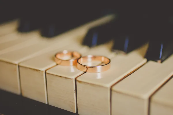 Bruiloft gouden ringen op vintage piano — Stockfoto