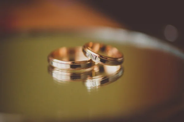 Brides and grooms wedding rings on mirror. Stock Image