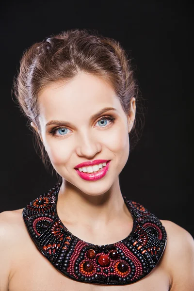 Porträtt av en vacker leende brunett tjej med lyxiga hand gjort halsband. — Stockfoto