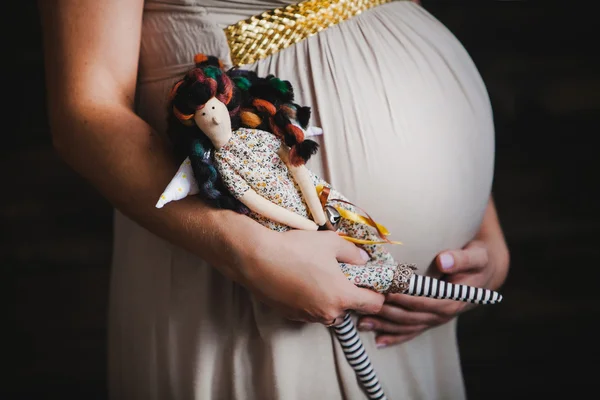 Nahaufnahme des Schwangerschaftsbauches mit einer Tilda-Puppe. Mutterschaftskonzept — Stockfoto