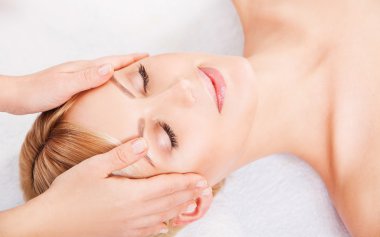 Beyaz arka plan üzerinde kaplıca tedavisi alma genç çekici kadın. Yüz masajı. 