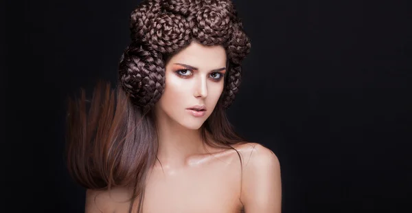 Mooie vrouw de mannequin met een creatieve pigtails hairstyling. — Stockfoto