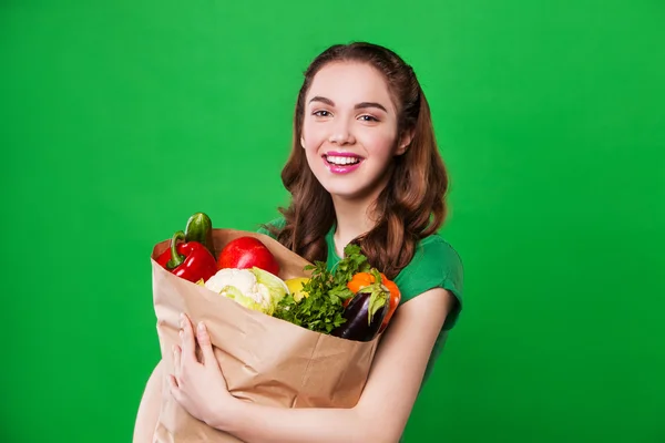 年轻的微笑女子捧着满满的健康食品一袋。购物 — 图库照片