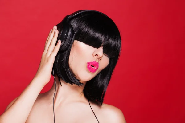 Mujer escuchando música en auriculares disfrutando de un baile . — Foto de Stock