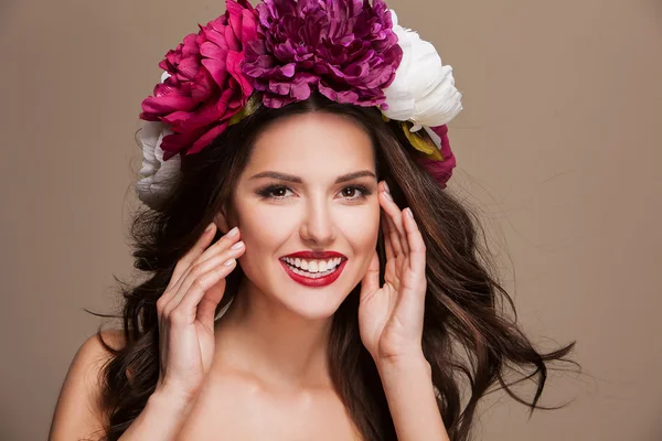 Modelo sorridente feliz sexy com cabelo curle e flores brilhantes em sua cabeça — Fotografia de Stock