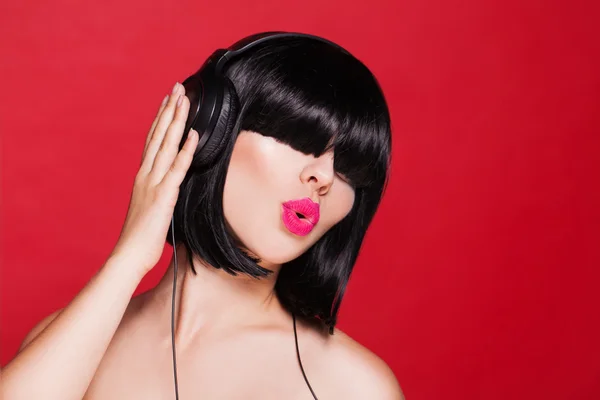 Woman listening to music on headphones enjoying a dance. Closeup portrait of beautiful girl with pink lips — Stock Photo, Image