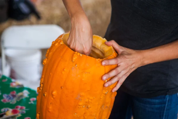 Holidays, halloween, decoration and people concept - close up of woman with pumpkins