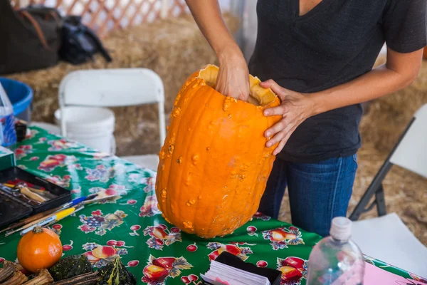 Holidays, halloween, decoration and people concept - close up of woman with pumpkins