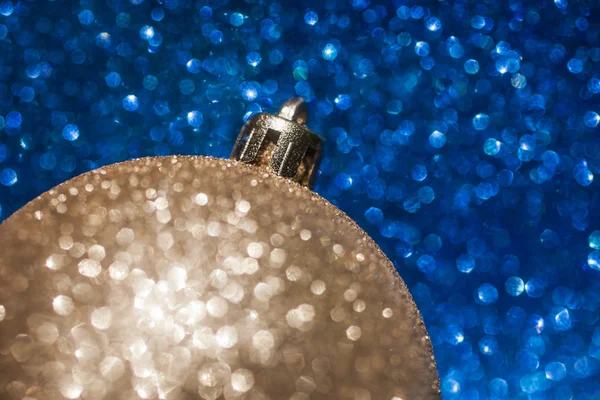 Bola de Navidad dorada sobre fondo de brillo azul —  Fotos de Stock