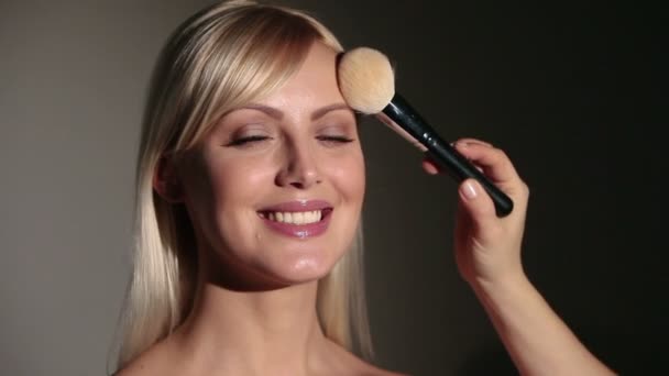 Maquillador con pincel de polvo, rostro ruborizado del modelo — Vídeo de stock
