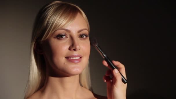 Model krijgt make-up. Professionele make-up artiest blusher is van toepassing op modellen gezicht. — Stockvideo