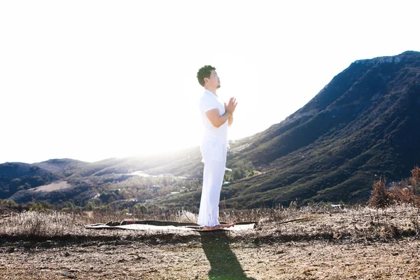 Asiatique homme médite en position de yoga sur les hautes montagnes au-dessus du ciel bleu . — Photo