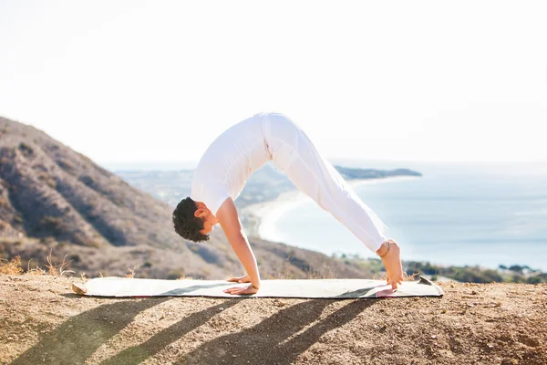 Asiatique homme médite en position de yoga sur les hautes montagnes au-dessus du ciel bleu . — Photo