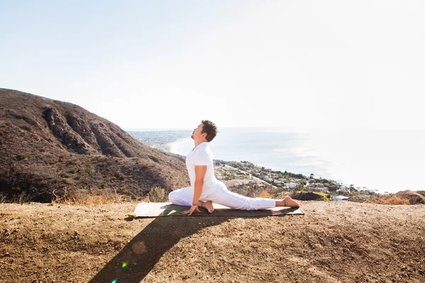 Asiatique homme médite en position de yoga sur les hautes montagnes au-dessus du ciel bleu . — Photo