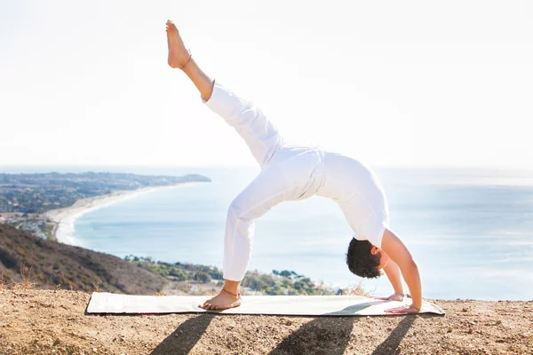 Asiatique homme médite en position de yoga sur les hautes montagnes au-dessus du ciel bleu . — Photo