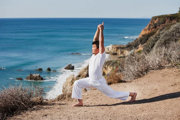 Asiatique homme médite en position de yoga sur les hautes montagnes au-dessus du ciel bleu . — Photo