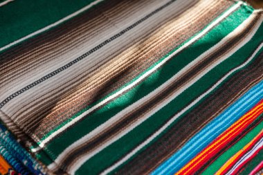 Satırda renkli Meksika serapes asmak.