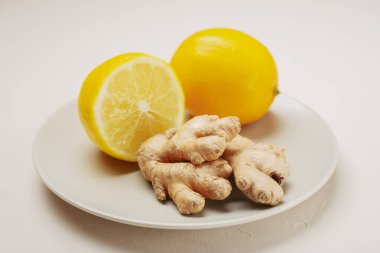 Limonata detoks malzemesi olarak zencefil ve limon bir tabakta..