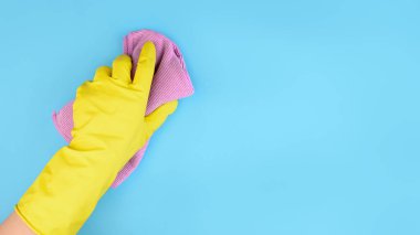 Sarı eldiven ve mavi arka plan temizleme konsepti. Metin için boş alanı var..