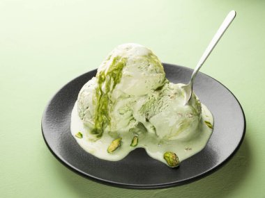 Bir tabakta erimiş şam fıstıklı dondurma.