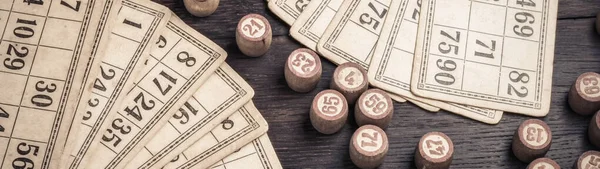 Cards and lotto kegs on a wooden background in vintage style banner.