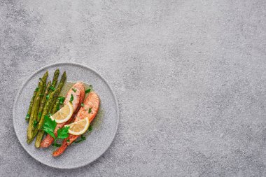 Fotokopi odası görünümlü bir tabakta kuşkonmaz ile pişirilmiş somon filetosu