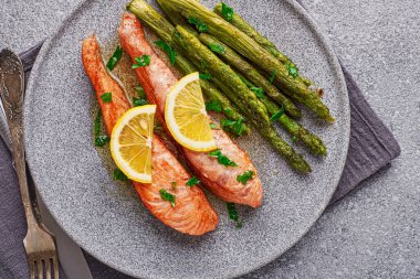 Top view cooked salmon fillet with asparagus in a plate close-up