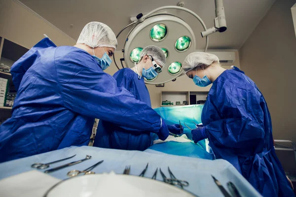 일하는 수술중인 의료용 마스크를 가환자를 수술하기 분야의 의사들 스톡 사진