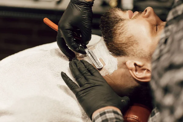 理发师在理发店刮胡子 用黑色手套把理发师的双手合拢在一起 给客人刮胡子 — 图库照片