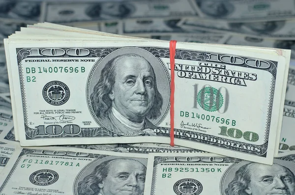 100 dolar arka planda yığılı. Para konsepti ve finans. İş geçmişi