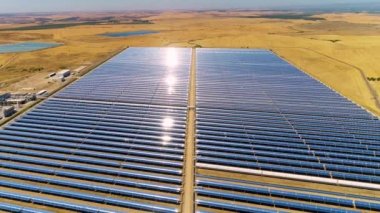 Güneş panelleri (güneş pili) olan bir çiftliğin 4 K Aerial görüntüsü. Güneş alanı üzerinde uçan yenilenebilir enerji konsepti