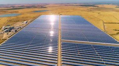 Güneş panelleri (güneş pili) olan bir çiftliğin 4 K Aerial görüntüsü. Güneş alanı üzerinde uçan yenilenebilir enerji konsepti